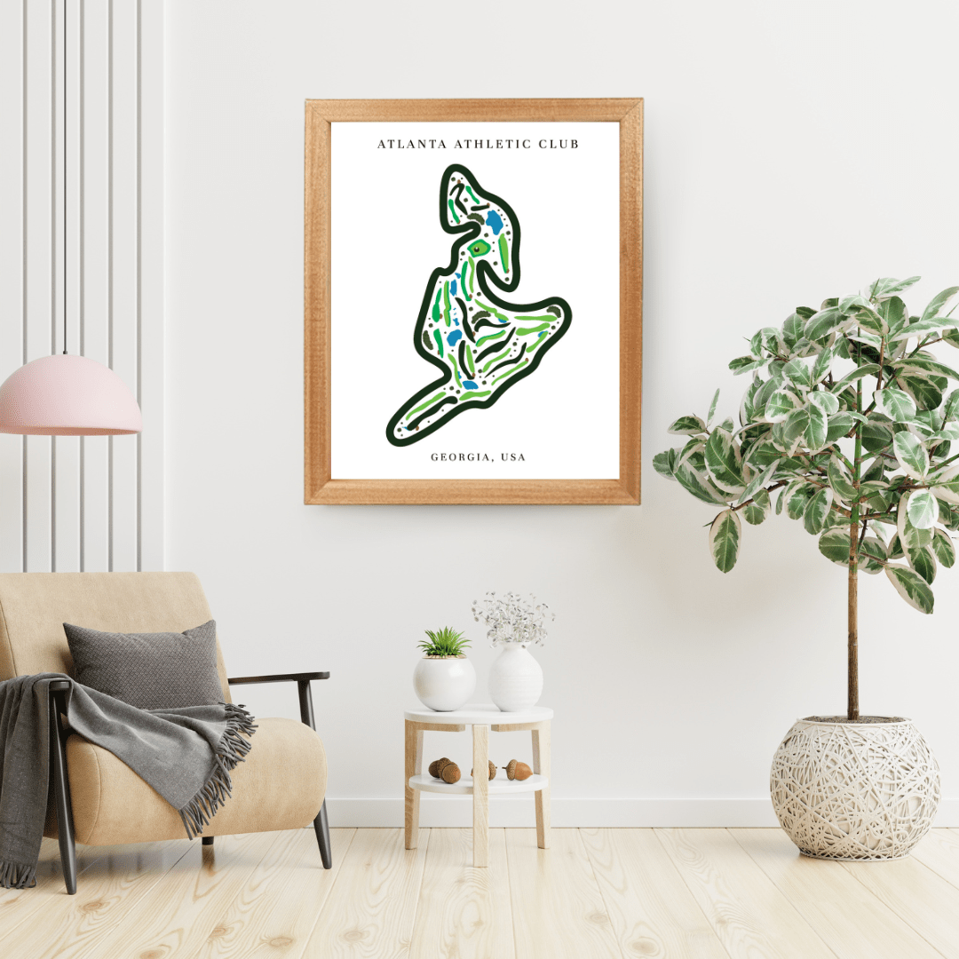 Framed map of Atlanta Athletic Club in a living room setting with a plant and chair.